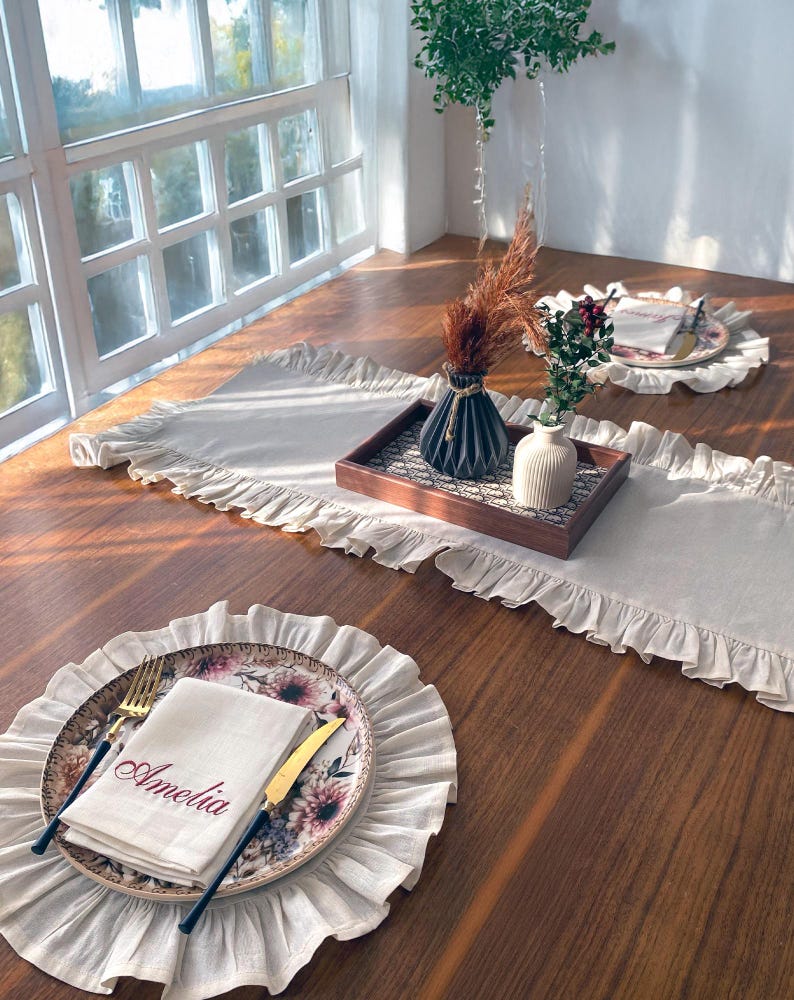 Soft ruffled table runner in white linen, styled for spring table decor and cozy gatherings. This French table runner complements french tablecloth and boho table runner themes. Ideal as a christmas runner, halloween tablecloth, or everyday white runner. A charming french tablecloth look, perfect for French table runner lovers and unique ruffled runner designs.