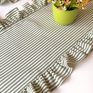 Green striped table runner with ruffled edges displayed on dining table, perfect for spring entertaining and farmhouse style decor.