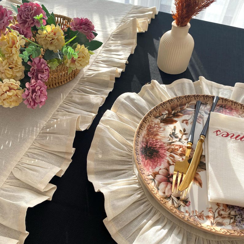 Soft ruffled table runner in white linen, styled for spring table decor and cozy gatherings. This French table runner complements french tablecloth and boho table runner themes. Ideal as a christmas runner, halloween tablecloth, or everyday white runner. A charming french tablecloth look, perfect for French table runner lovers and unique ruffled runner designs.