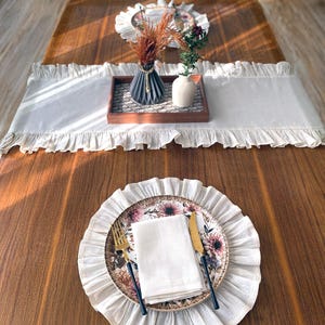Soft ruffled table runner in white linen, styled for spring table decor and cozy gatherings. This French table runner complements french tablecloth and boho table runner themes. Ideal as a christmas runner, halloween tablecloth, or everyday white runner. A charming french tablecloth look, perfect for French table runner lovers and unique ruffled runner designs.