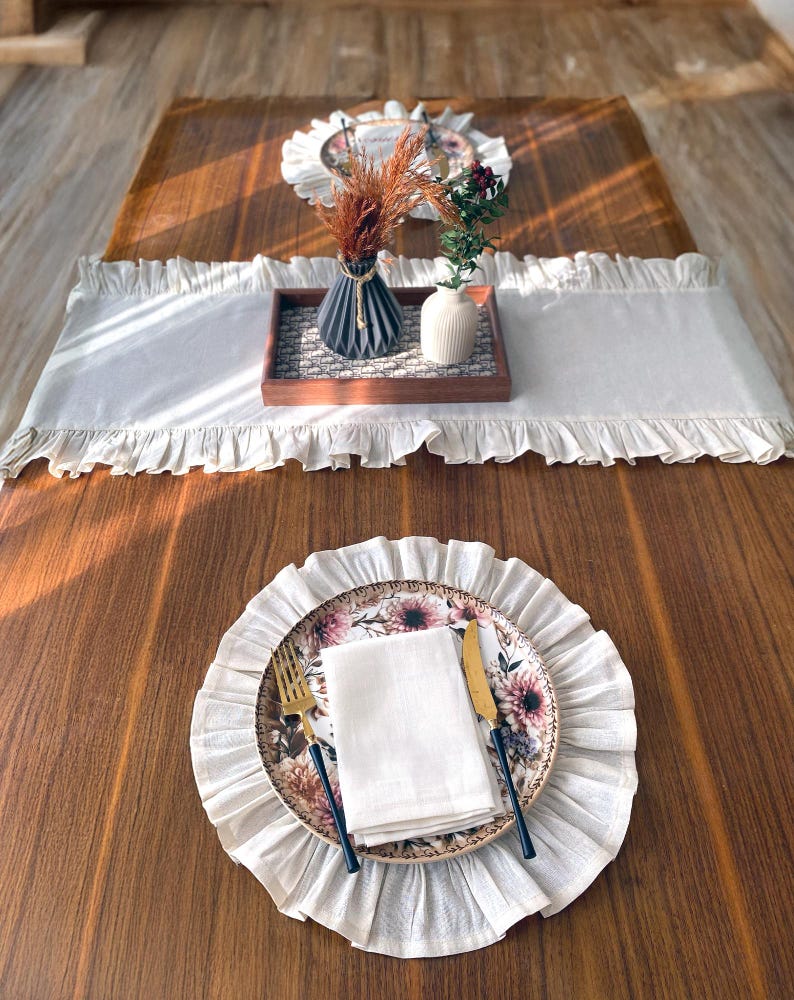 Soft ruffled table runner in white linen, styled for spring table decor and cozy gatherings. This French table runner complements french tablecloth and boho table runner themes. Ideal as a christmas runner, halloween tablecloth, or everyday white runner. A charming french tablecloth look, perfect for French table runner lovers and unique ruffled runner designs.