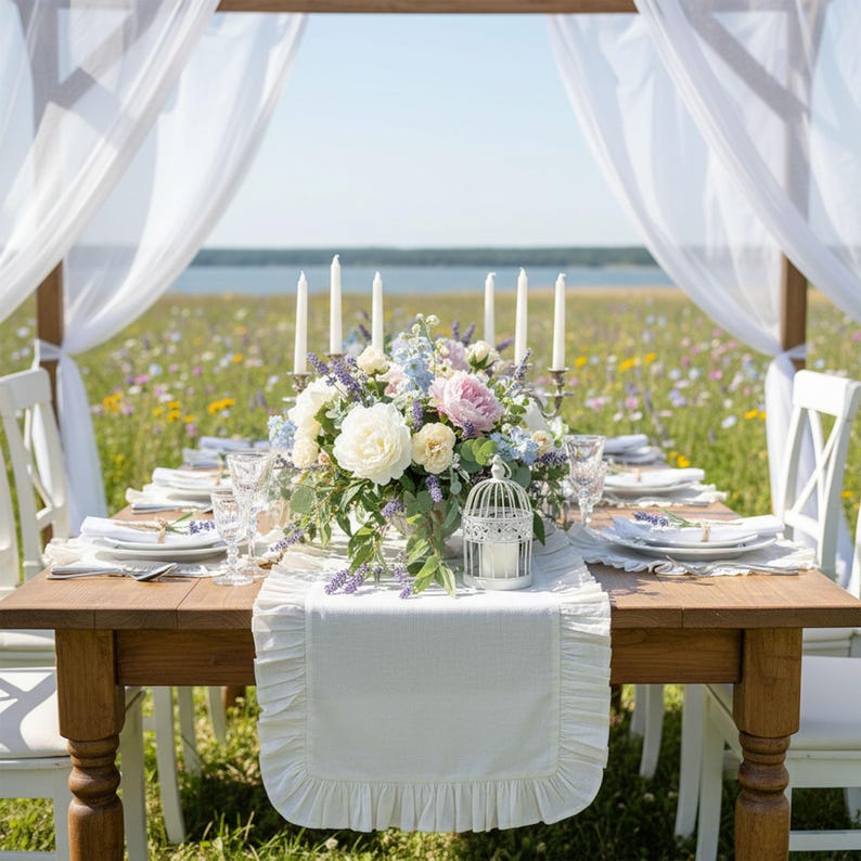 Romantic beach wedding table setting, white linen runner with lavender and candle arrangements