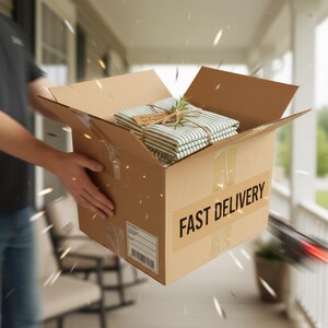 Peut inclure: Une bo&icirc;te en carton marron avec l'inscription "FAST DELIVERY" est ouverte, r&eacute;v&eacute;lant un lot de tissu &agrave; rayures li&eacute; avec de la ficelle et du romarin. La bo&icirc;te est en cours de livraison.