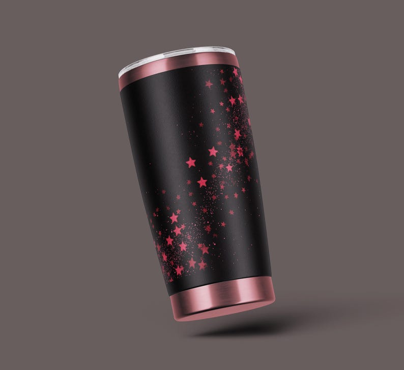 K&ouml;nnte beinhalten: Ein schwarzer und ros&eacute;goldener Becher mit einem rosa Sternenmuster.