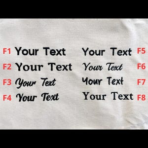 May include: Close-up of a cream-colored fabric with eight instances of the text "Your Text" in black, each in a different font. The letters F1 through F8 are in red.