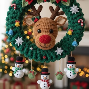 Op de afbeelding: Een handgemaakte kerstkrans met een gehaakte rendierkop, een rode neus en bruine geweien. De groene krans is versierd met sneeuwvlokken, zuurstokken, belletjes en sneeuwmannen. Een feestelijke, handgemaakte decoratie voor de feestdagen.