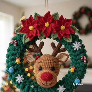Op de afbeelding: Een handgemaakte kerstkrans met een gehaakte rendierkop, een rode neus en geweien. De krans is versierd met rode poinsettia's, sneeuwvlokken, zuurstokken en bellen. De krans is groen en heeft een feestelijk vakantiethema.