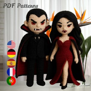 May include: Two crocheted vampire dolls, a male and a female, stand side-by-side. The male doll wears a black suit with a red-lined cape. The female doll is in a red dress and black cape. The text "PDF Patterns" is at the top.