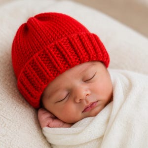 Puede incluir: Un gorro de punto de color rojo brillante que presenta un diseño de puño grueso y acanalado. El gorro está confeccionado con una textura de hilo grueso y una forma clásica de corona redondeada, ofreciendo una prenda sencilla para la cabeza.