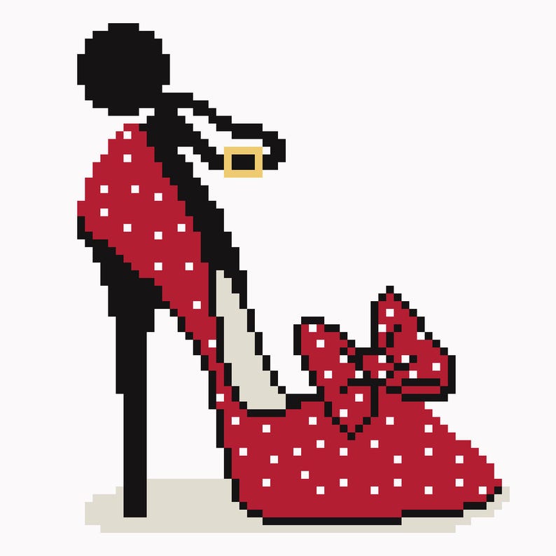 May include: A pixelated image of a red high-heeled shoe with white polka dots and a bow. The shoe has a black heel and strap with a gold buckle. The design is reminiscent of a retro or vintage style.