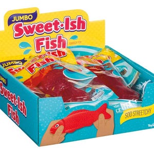 May include: A display box of Jumbo Sweet-ish Fish, a squeezable toy. The box is teal with the product name in red and white. Inside are several red fish toys in clear packaging. The box has a yellow header with the product name and blue water droplet graphics.