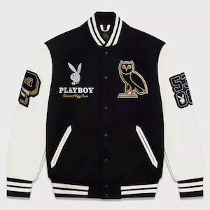 Puede incluir: Chaqueta universitaria negra y blanca con mangas blancas. Presenta el logo de Playboy, un gráfico de búho y el número 53. La chaqueta tiene cuello y puños a rayas, y parches en las mangas.