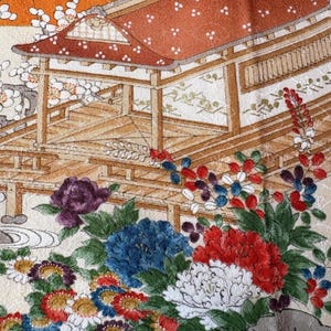 以下が含まれることがあります： 日本のデザインが施されたテキスタイルのクローズアップ。 赤い屋根の伝統的な建物と、青、赤、白の色合いの花々が描かれています。 クリーム色の背景に、鮮やかなコントラストを生み出しています。