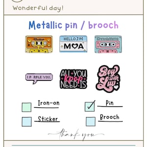 Puede incluir: Imagen que presenta varios pines y broches metálicos con diseños coloridos. Los pines incluyen diseños de cintas de cassette con las palabras "Butter" y "Dynamite", y otros diseños con texto. También incluye el texto "Metallic pin / brooch".