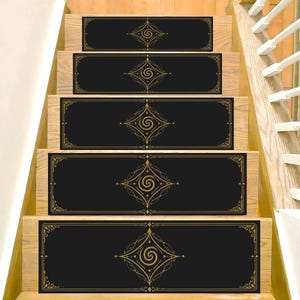 May include: A set of five rectangular stair treads in black with a gold-colored central diamond-shaped motif featuring a spiral design. Each tread is bordered by thin gold lines and decorative corner accents, installed on wooden stairs.