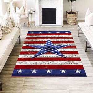 May include: A rectangular rug with a patriotic design. The rug features red and white stripes, blue borders with white stars, and a large blue star in the center. The design has a distressed, vintage look.