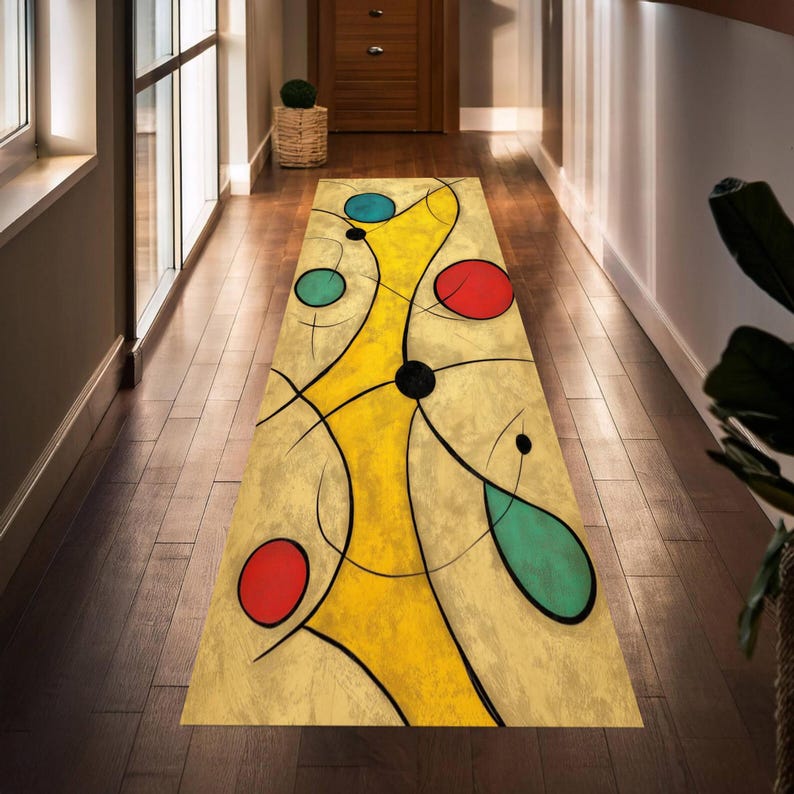 May include: A rectangular abstract art rug with a yellow central design, black lines, and red, blue, and teal circles. The rug is placed on a dark wood floor in a hallway, adding a pop of color and artistic flair to the space.