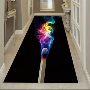 May include: A rectangular black rug featuring a large, lit match with colorful smoke. The smoke transitions from blue to pink, yellow, and green. The rug is designed for a hallway or entryway.