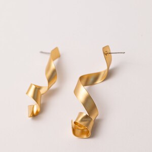 a pair of gold earrings on a white background