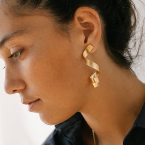 a close up of a person wearing a pair of earrings