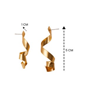 a pair of gold earrings with a measuring line