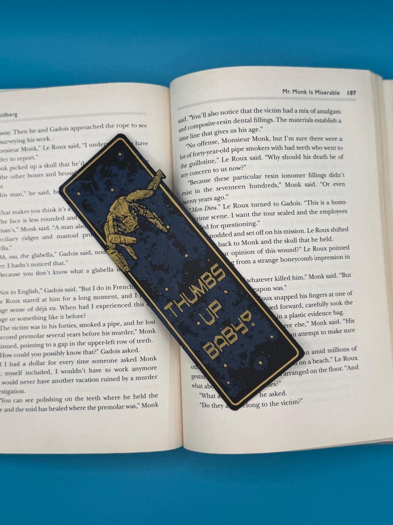 Rocky alien bookmark with a golden mechanical arm giving thumbs up on a blue background, Project Hail Mary inspired, sci fi. THUMBS UP BABY