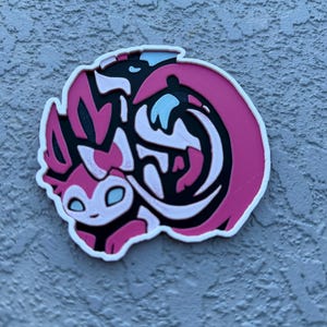 Round Eeveelution coaster Sylveon in cute Pokemon anime art.
