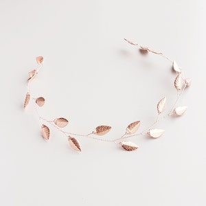 May include: A rose gold leaf hair vine with delicate leaves arranged on a thin wire. The vine is perfect for adding a touch of elegance to any hairstyle.