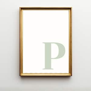Pode incluir: Uma impress&atilde;o de arte de parede retangular com uma letra P mai&uacute;scula grande em verde s&aacute;lvia p&aacute;lido, centralizada num fundo branco puro. A impress&atilde;o est&aacute; emoldurada numa moldura fina de metal dourado com acabamento liso e polido.