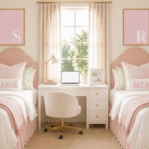 Pode incluir: Duas camas de solteiro com cabeceiras estofadas em rosa, roupa de cama branca e saias de cama com babados rosas. Cada cama possui uma almofada lombar branca com os nomes Carol e Mia bordados em rosa. Acima de cada cama, um quadro rosa exibe uma letra S ou R branca. Uma escrivaninha branca com laptop, lumin&aacute;ria e cadeira girat&oacute;ria branca fica entre as camas.