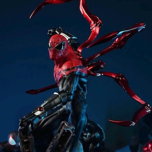 May include: A detailed figurine of Spider-Man in a dynamic pose, featuring a red and black color scheme. The figure has multiple red mechanical spider legs extending from its back. The background is a dark blue.