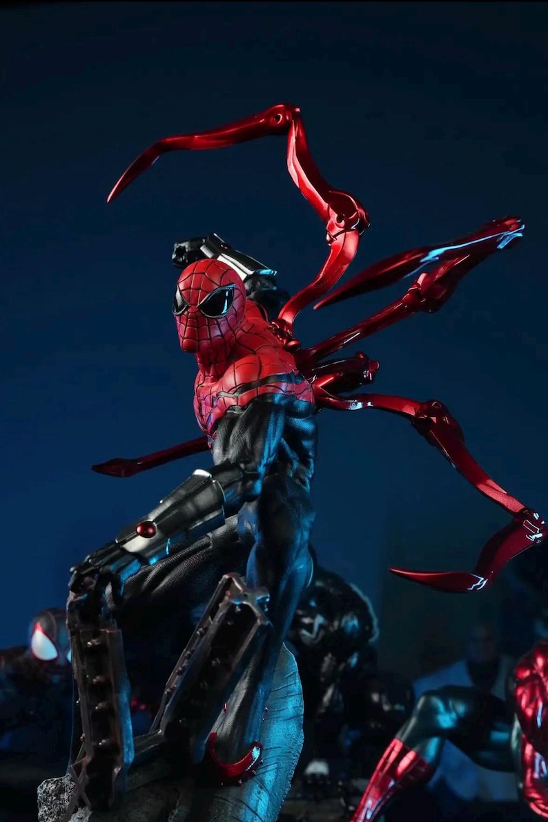 May include: A detailed figurine of Spider-Man in a dynamic pose, featuring a red and black color scheme. The figure has multiple red mechanical spider legs extending from its back. The background is a dark blue.