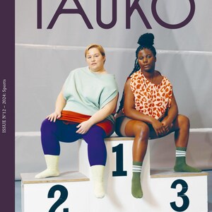 May include: The "TAUKO" magazine cover shows two people on a podium marked with the numbers 1, 2, and 3. The magazine title is in large purple letters. The cover also includes the text "Sewing. Climate. Culture. Community."