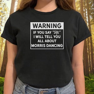 May include: A black t-shirt with a white warning sign that says "WARNING IF YOU SAY "Hi" I WILL TELL YOU ALL ABOUT MORRIS DANCING"