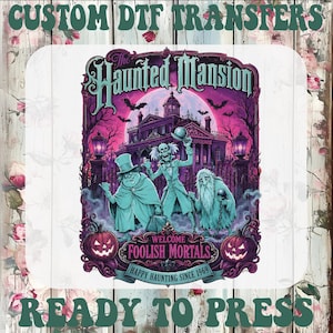 May include: A graphic DTF transfer featuring The Haunted Mansion with three ghosts, a mansion, bats, and two jack-o'-lanterns in purple and teal tones. Text reads: The Haunted Mansion, Welcome Foolish Mortals, Happy Haunting Since 1969, Custom DTF Transfers, Ready To Press.