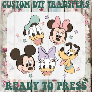 May include: A custom DTF transfer sheet featuring cartoon character heads including Mickey Mouse, Minnie Mouse, Donald Duck, Daisy Duck, and Pluto, accented with small stars. The text CUSTOM DTF TRANSFERS READY TO PRESS is printed in green.