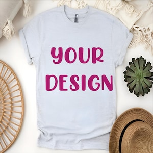 May include: A light gray t-shirt with the words "YOUR DESIGN" printed in pink.