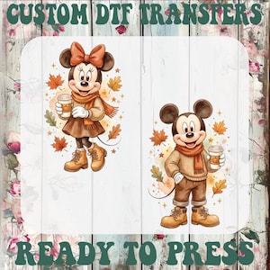 May include: Custom DTF transfers ready to press featuring two cartoon mice characters dressed in autumn attire. Each character wears a sweater, scarf, and boots while holding a coffee cup with a pumpkin icon, surrounded by falling maple leaves.