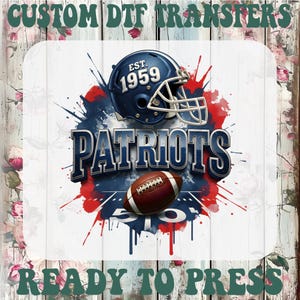 May include: A DTF transfer design featuring a navy blue football helmet with the text "EST. 1959" and the word "PATRIOTS" in a 3D effect. A brown football is below the text, with red and blue paint splatter accents. The words "CUSTOM DTF TRANSFERS" and "READY TO PRESS" are at the top and bottom.