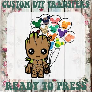 May include: A cartoon image of a brown Groot character holding a bunch of colorful balloons with Mickey Mouse designs. The image has the text "CUSTOM DTF TRANSFERS" at the top and "READY TO PRESS" at the bottom.