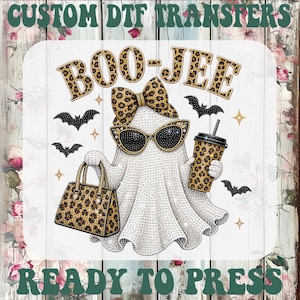 May include: A custom DTF transfer featuring a white ghost wearing leopard print sunglasses and a matching bow. The ghost holds a leopard print handbag and a matching tumbler. The text reads CUSTOM DTF TRANSFERS and BOO-JEE READY TO PRESS.