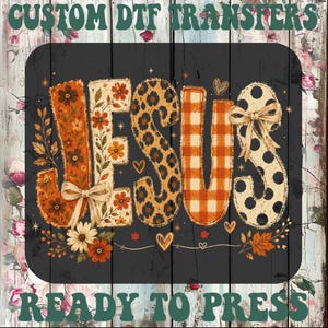 May include: A custom DTF transfer sheet featuring the word JESUS in large letters with varied patterns including floral, leopard print, orange gingham, and black polka dots. The design includes small bows, hearts, and autumn leaves on a dark background.
