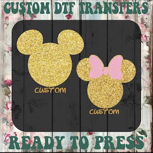 May include: Two glittery gold mouse head designs, one with a pink bow, on a black background. The word "CUSTOM" is below each design. The text "CUSTOM DTF TRANSFERS" and "READY TO PRESS" are at the top and bottom.
