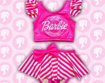 May include: Pink and white striped two-piece outfit with a pink top that says "Come on Barbie let's go party" and a matching skirt with a pink bow.