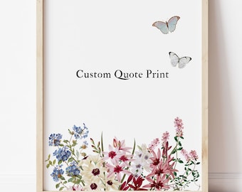 Op de afbeelding: Een ingelijste print in een lichthouten lijst met de tekst Custom Quote Print in het zwart, twee vlinders in blauw en wit, en een kleurrijk botanisch arrangement van blauwe, witte, roze en rode bloemen onderaan.