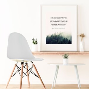 May include: A framed print with a quote about nature and a misty forest scene. The quote reads: "Climb the mountains and get their good tidings. Nature's peace will flow into you as sunshine flows into trees. The winds will blow their own freshness into you, and the storms their energy, while cares will drop off like autumn leaves." - John Muir, An American Naturalist, 1838-1914