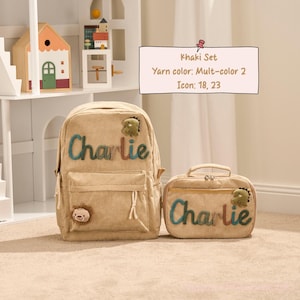 May include: Khaki corduroy backpack and matching lunch bag set. The backpack and lunch bag have the name "Charlie" in colorful yarn. Each item features a small dinosaur and lion icon.