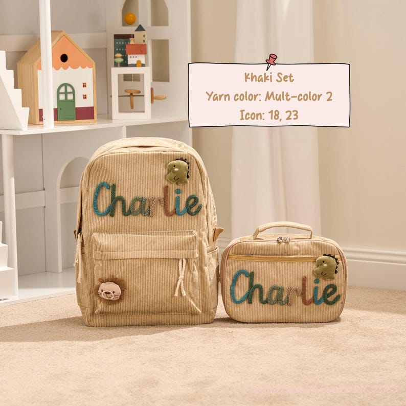 May include: Khaki corduroy backpack and matching lunch bag set. The backpack and lunch bag have the name "Charlie" in colorful yarn. Each item features a small dinosaur and lion icon.