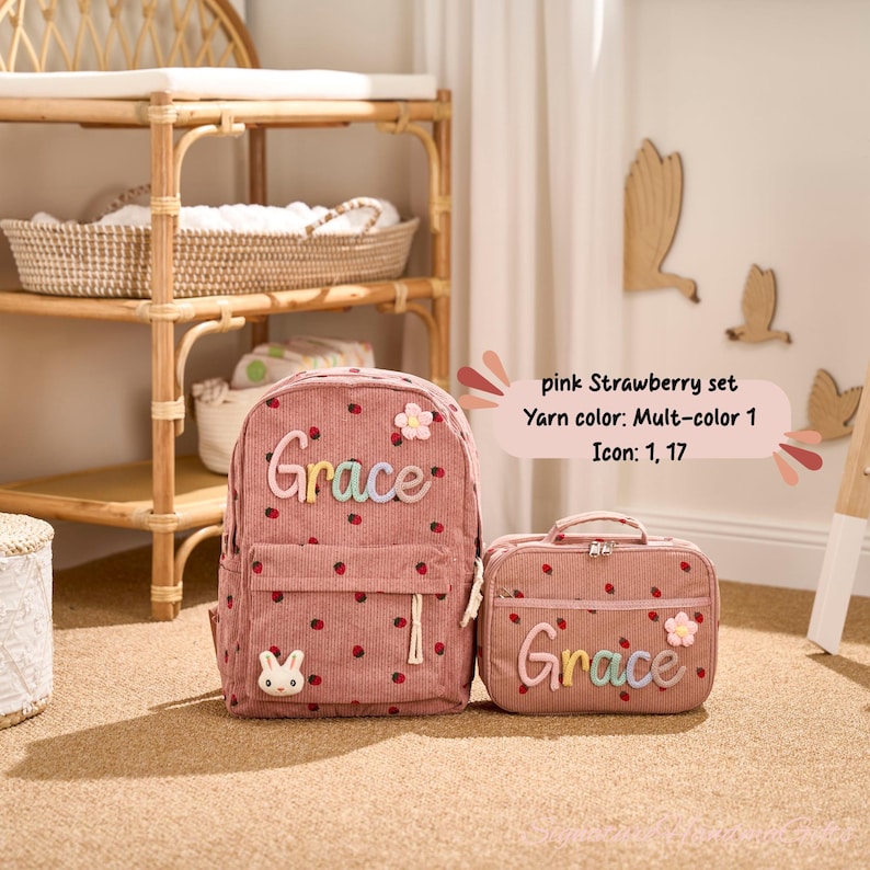May include: A pink corduroy backpack and matching lunch bag set. The backpack and lunch bag are decorated with a strawberry pattern, the name "Grace", and a flower. The backpack has a front pocket and a small bunny detail.