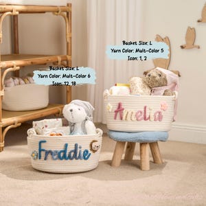 May include: Two white rope baskets, one with "Freddie" in blue and a lion icon, the other with "Amelia" in pink. Both are filled with items and a stuffed animal. The baskets are on a light-colored surface.
